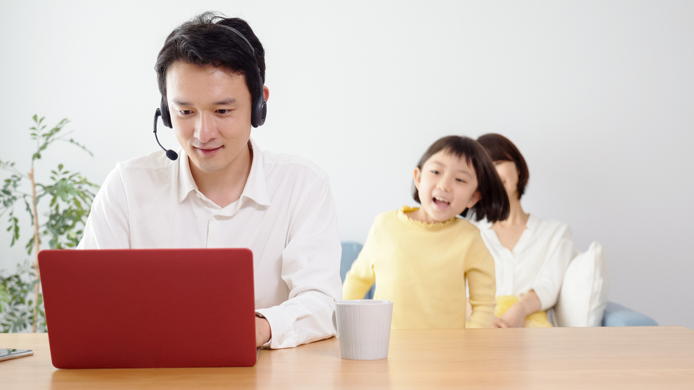 This is a photo of a man working from home wearing a headset.