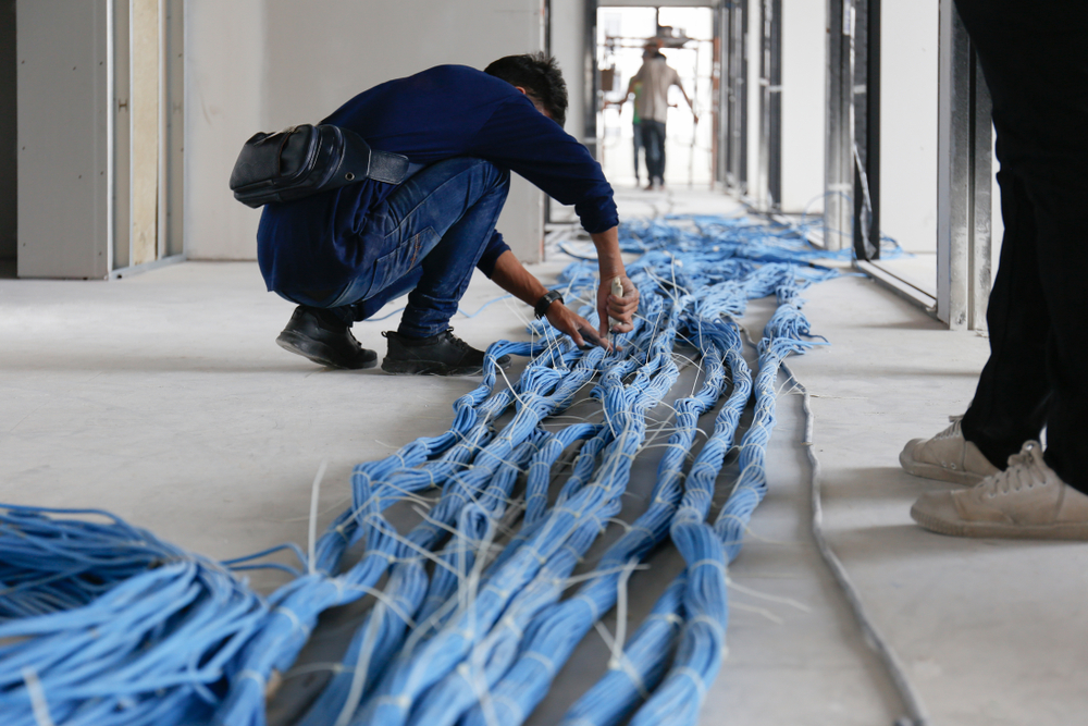 This is a photo of an engineer laying LAN cables.