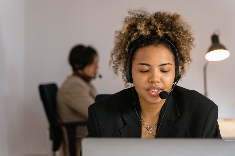 This is a photo of a lady using a headset in a coworking office.