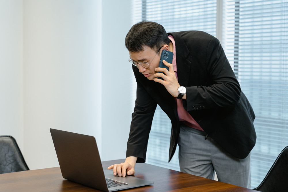 This is a photo of a man on his mobile phone with a worried look.