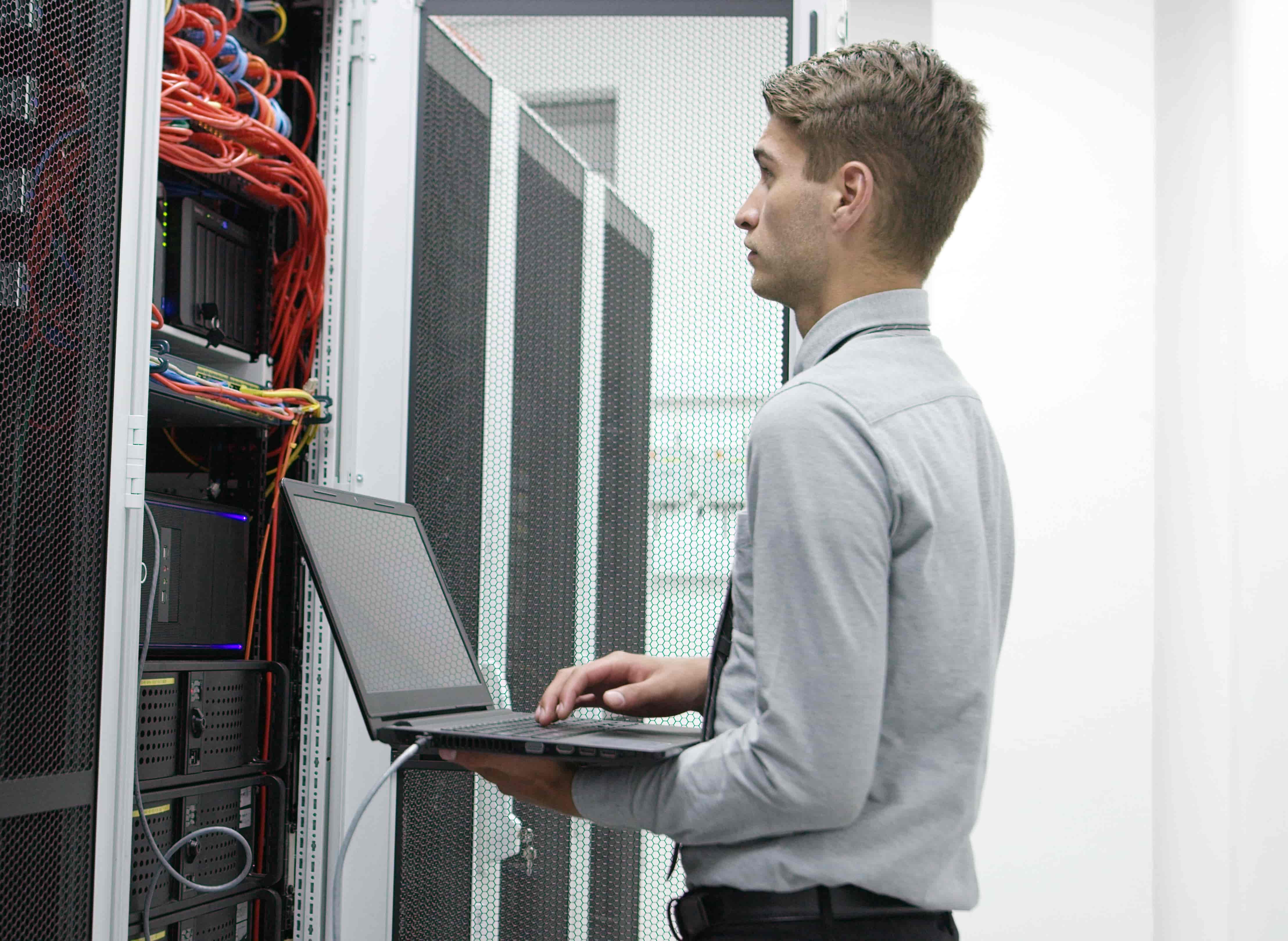 This is a photo of an engineer in front of an office server rack.