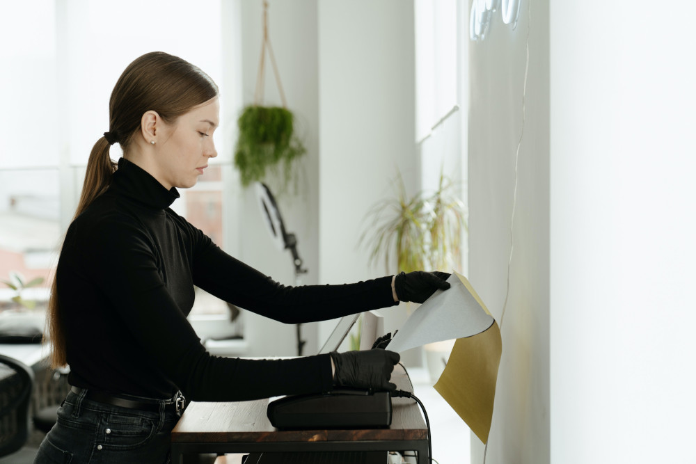 This is a photo of a woman feeding a fax machine.